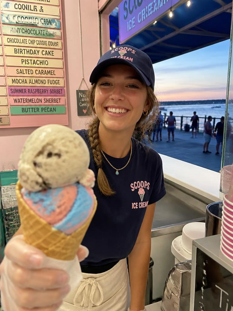 Student serving ice cream at a seaside sweet shop